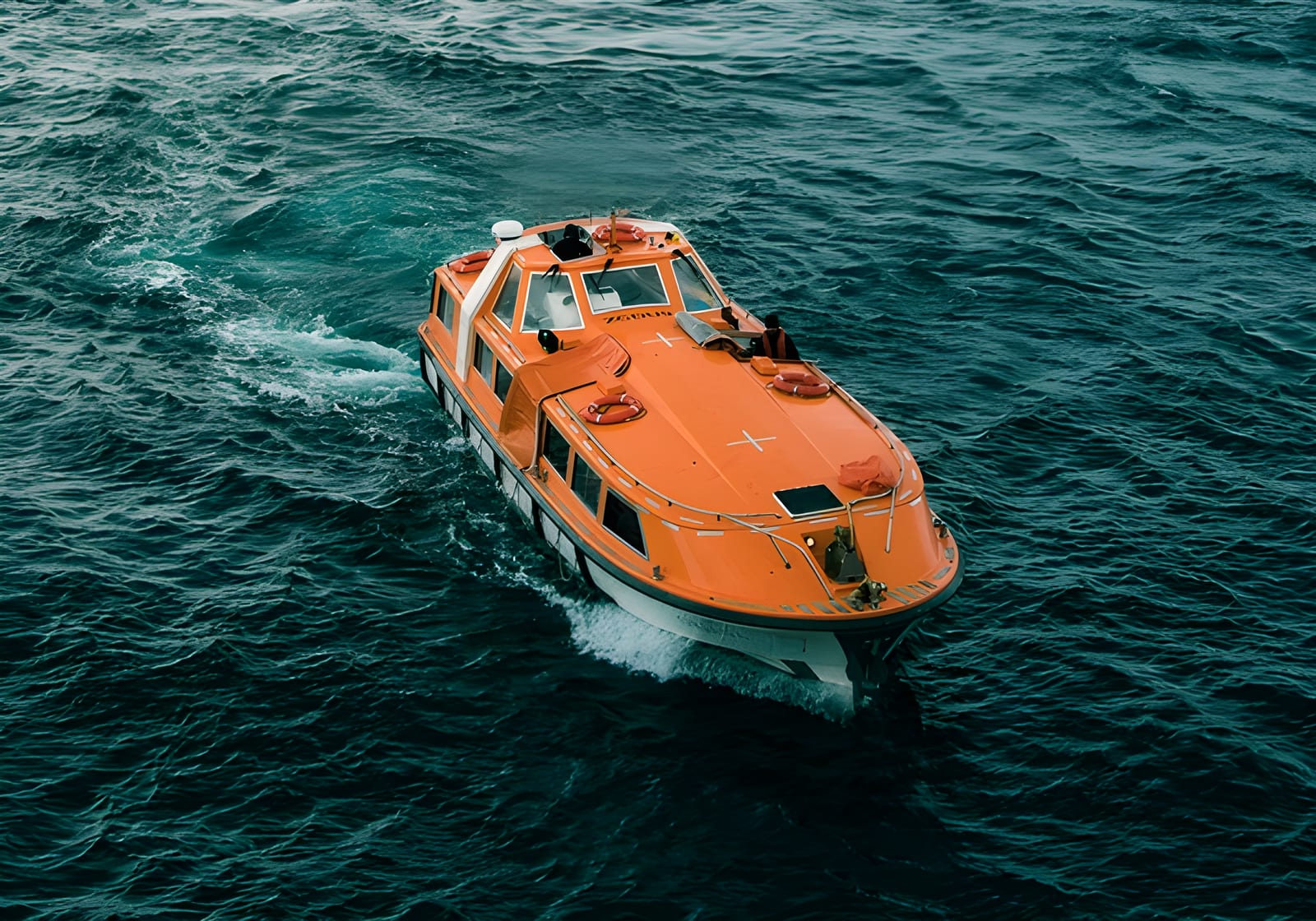 Enclosed lifeboat underway at sea